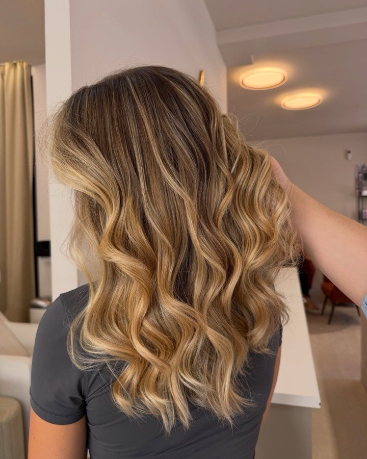 Ondas loiras com madeixas douradas, vistas de costas, depois do serviço no salão